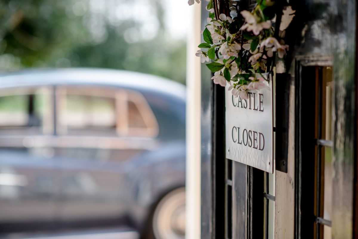 Back of office technology for wedding venue owners A doorway showing a Rollsroyce and a sign stating Castle Closed